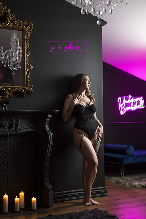 Woman posing in an Ottawa boudoir studio with candles and dramatic lighting